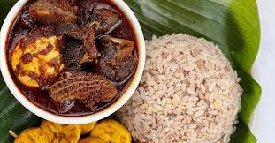 Ofada Rice served with stew and goat meat.